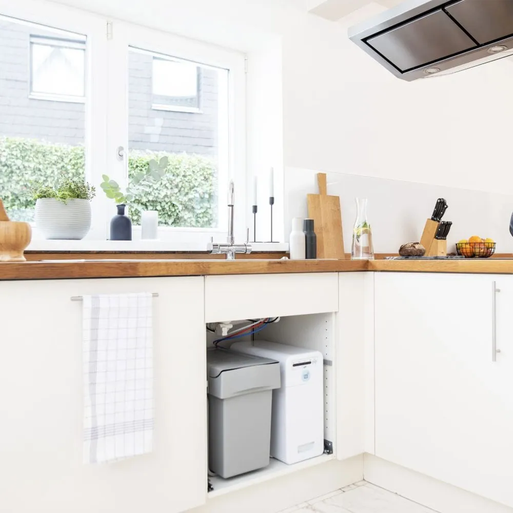 Moderne Küche mit Holzarbeitsplatte, Spüle, Pflanzen und Aufbewahrungsbehältern.