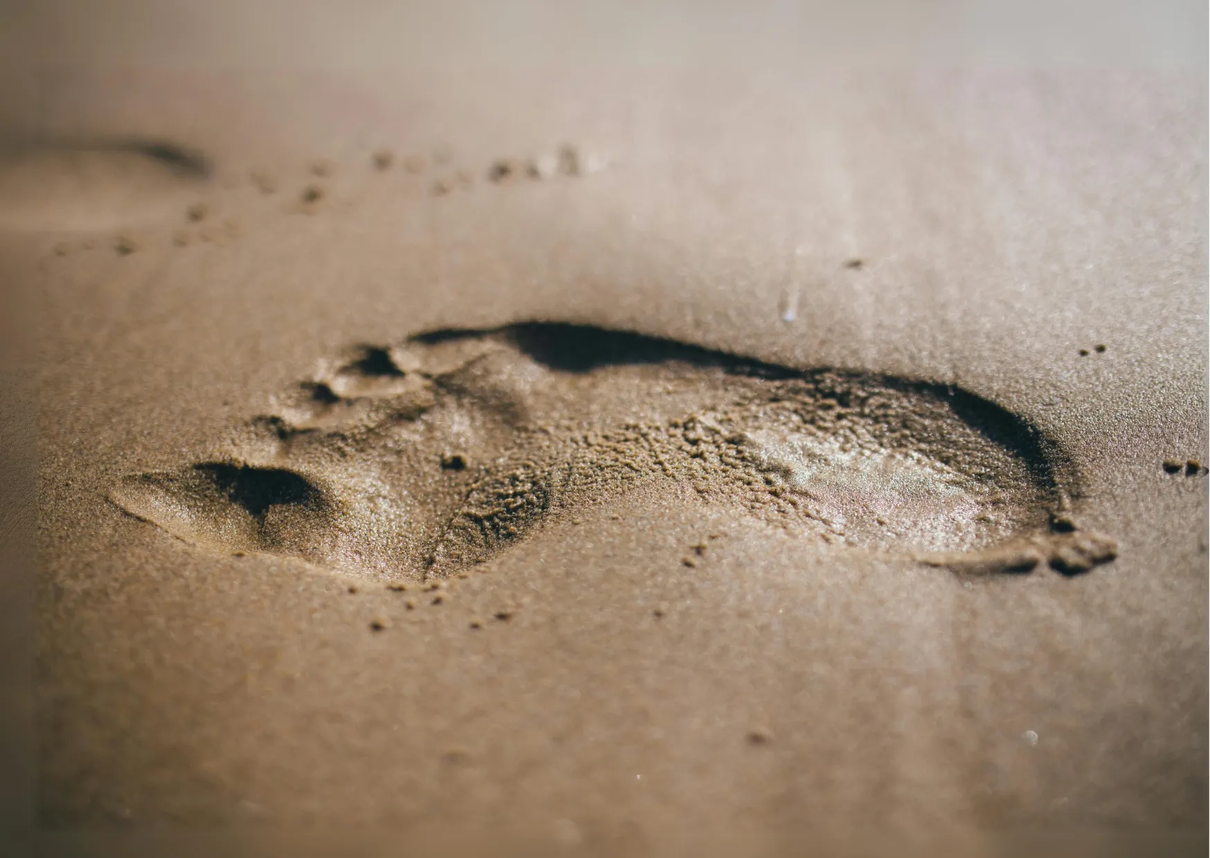 Fußabdruck im Sand als Symbol für Wasserfußabdruck und Nachhaltigkeit
