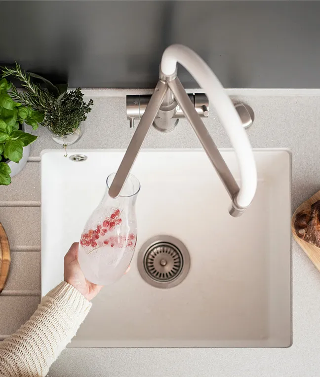Armatur mit Sprudelwasserfunktion über Spülbecken, daneben frische Zutaten