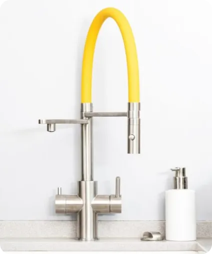 Moderner Wasserhahn mit gelbem Auslauf und zwei Hebeln auf weißer Spüle.