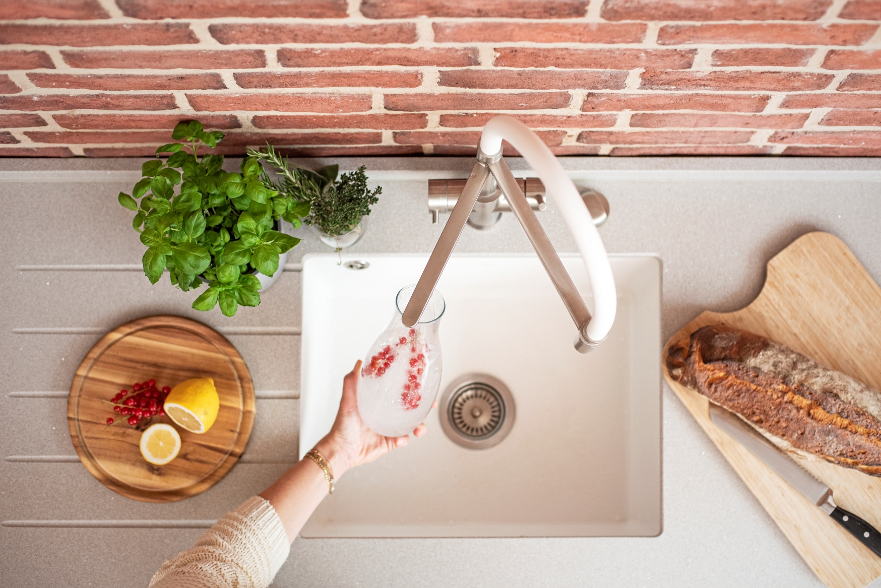 Küchenarmatur mit Sprudelfunktion, Person füllt Glas mit Sodawasser