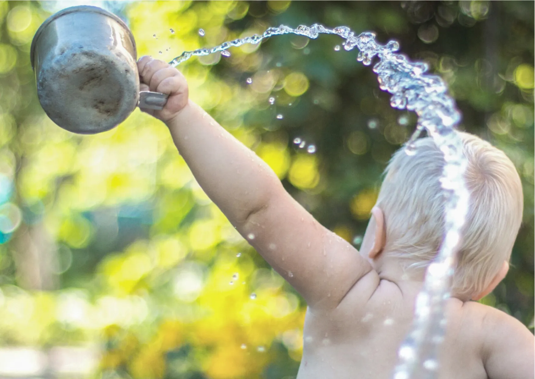 Kleinkind entdeckt Wasser spielerisch – Symbolbild zum Thema Wasser für Babys.