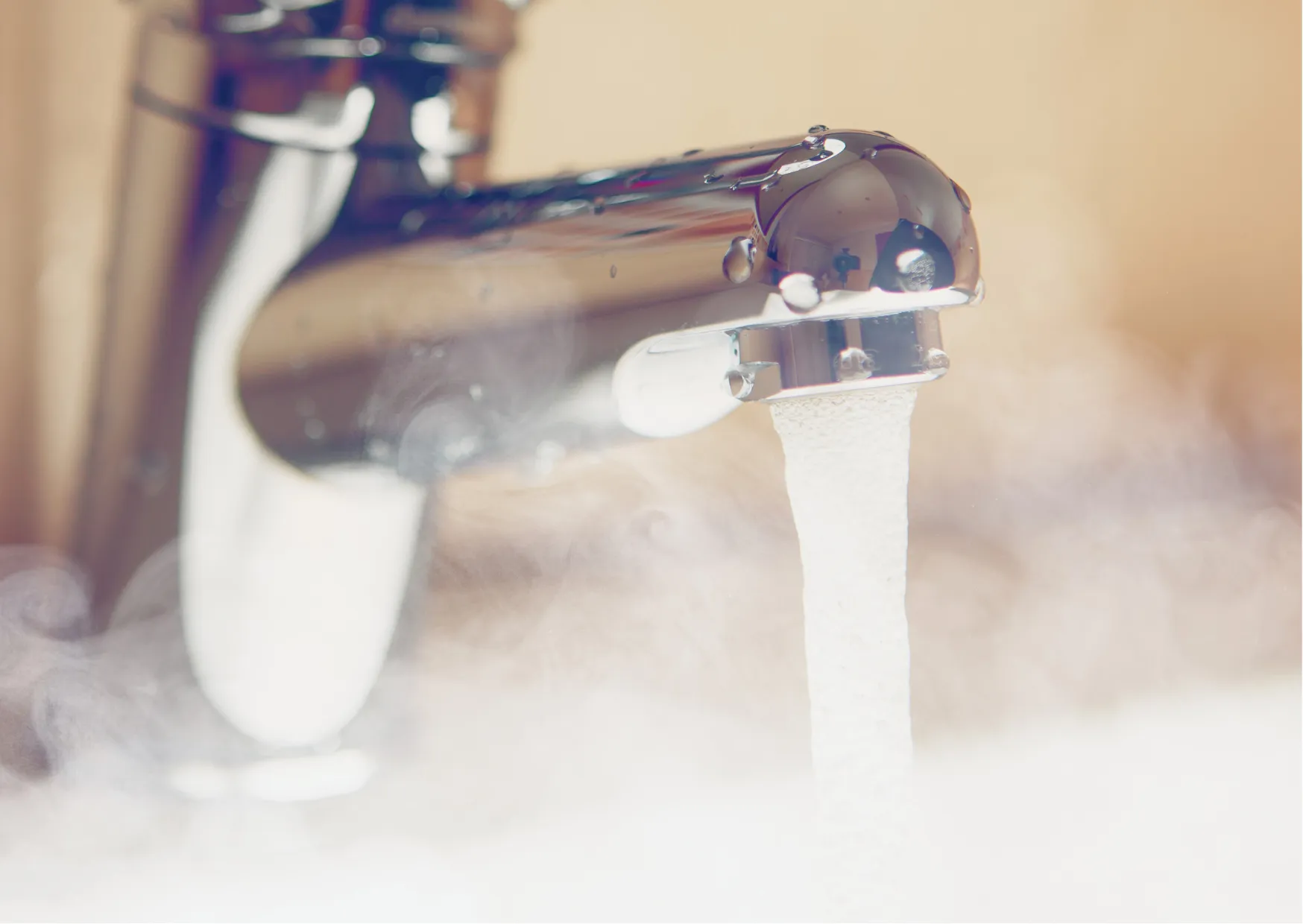 Ein Wasserhahn mit dampfendem Wasser, das ausläuft.