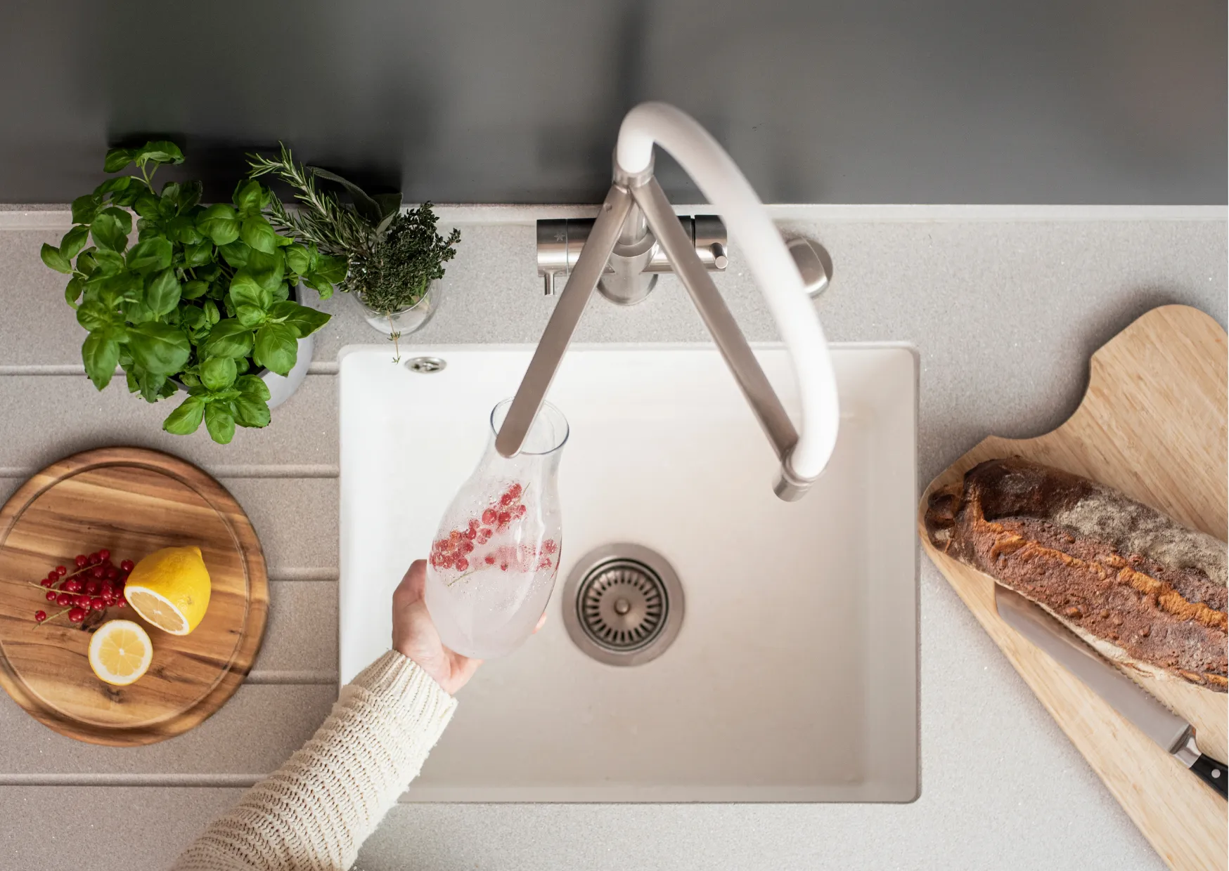 Küchenarmatur mit Sprudelfunktion, Person füllt Glas mit Sodawasser