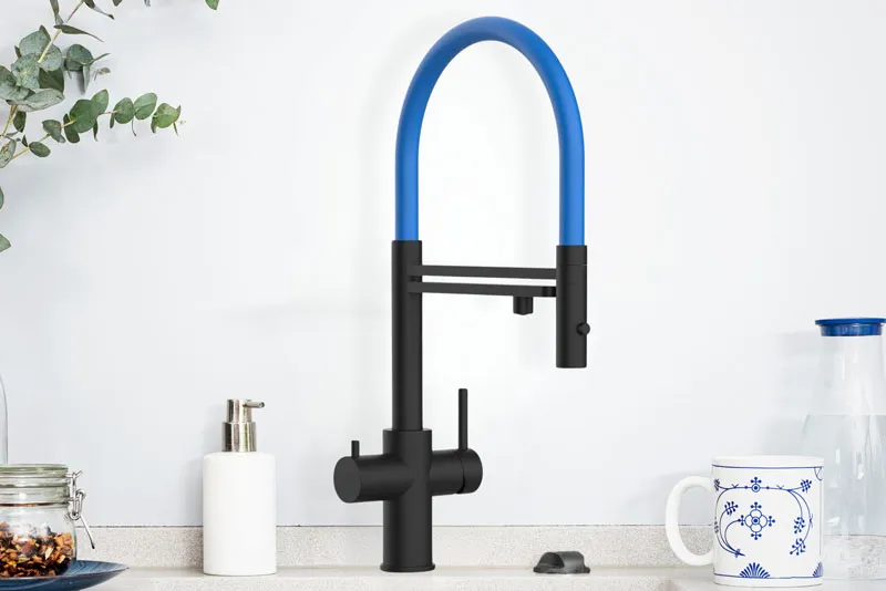 Moderne Küchenarmatur aus Edelstahl mit blauem Schlauch, einer Pflanze in einem Topf, einer Kaffeetasse und einem Glas mit Gewürzen auf einer Arbeitsfläche.